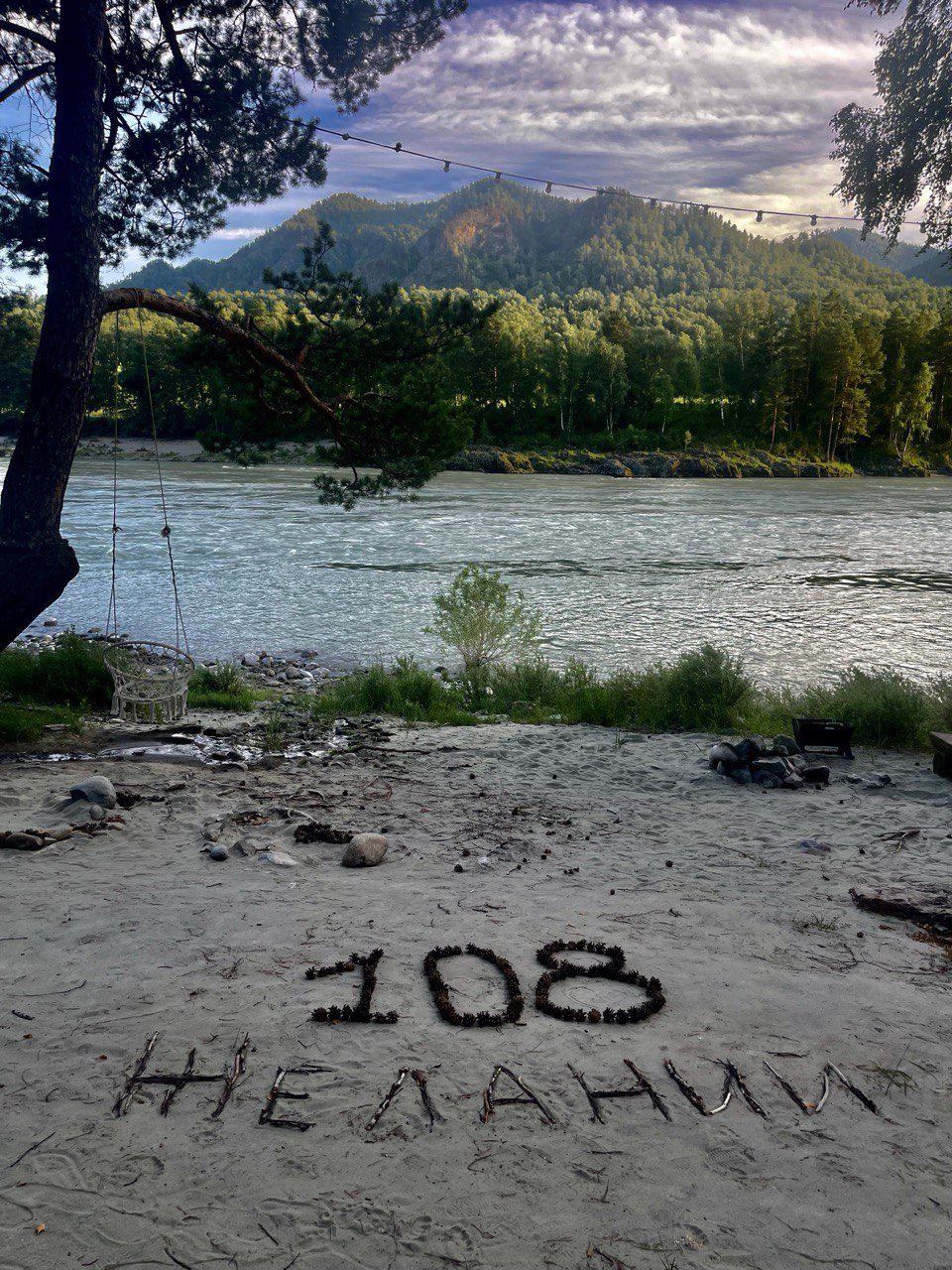 Надпись 108 желаний на песке у реки